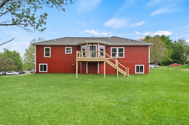 back of house featuring a wooden deck, a lawn, and stairs