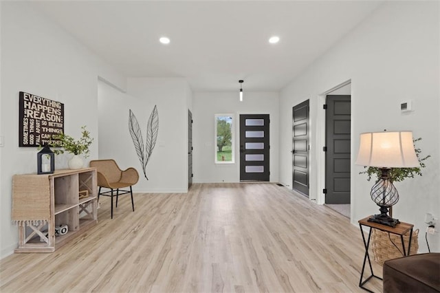 foyer featuring light wood-type flooring, baseboards, and recessed lighting