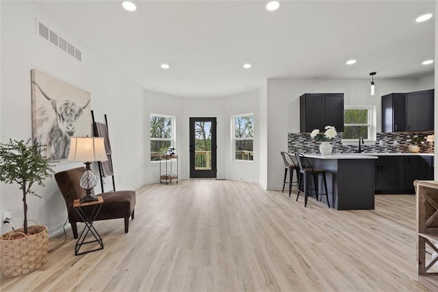 interior space featuring light countertops, visible vents, a kitchen breakfast bar, and dark cabinets