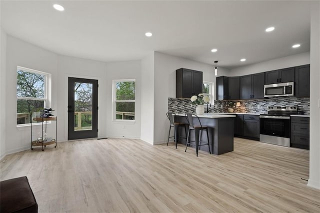 kitchen featuring plenty of natural light, light countertops, open floor plan, and appliances with stainless steel finishes