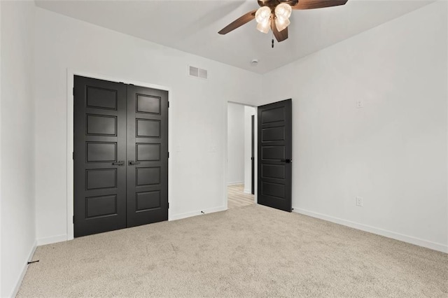 unfurnished bedroom with baseboards, visible vents, carpet floors, and ceiling fan