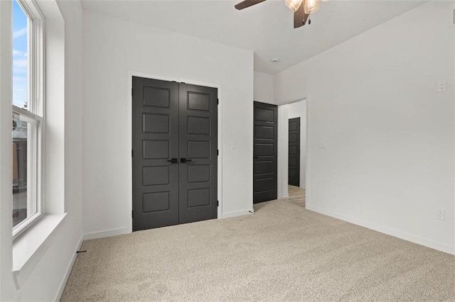 unfurnished bedroom with baseboards, carpet flooring, and a closet