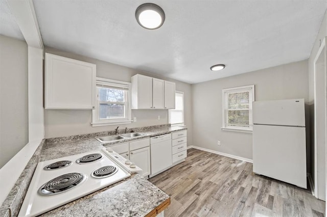 kitchen featuring white appliances, white cabinetry, and plenty of natural light