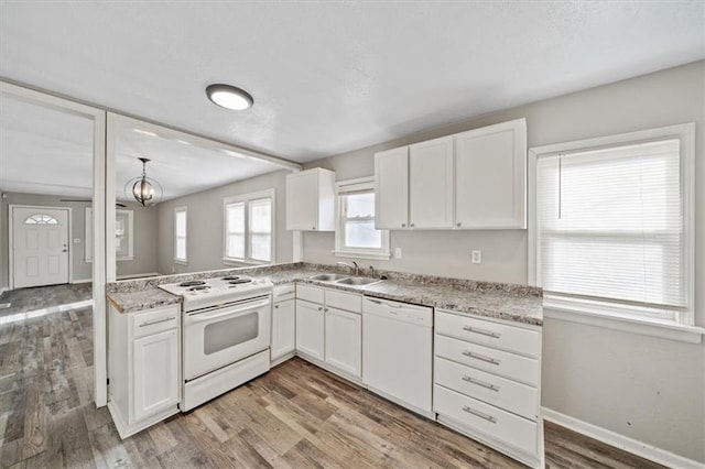 kitchen with white cabinetry, hardwood / wood-style floors, and white appliances