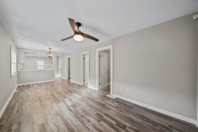 unfurnished living room featuring wood-type flooring and ceiling fan