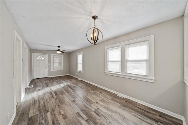 interior space featuring a textured ceiling, hardwood / wood-style floors, and ceiling fan with notable chandelier