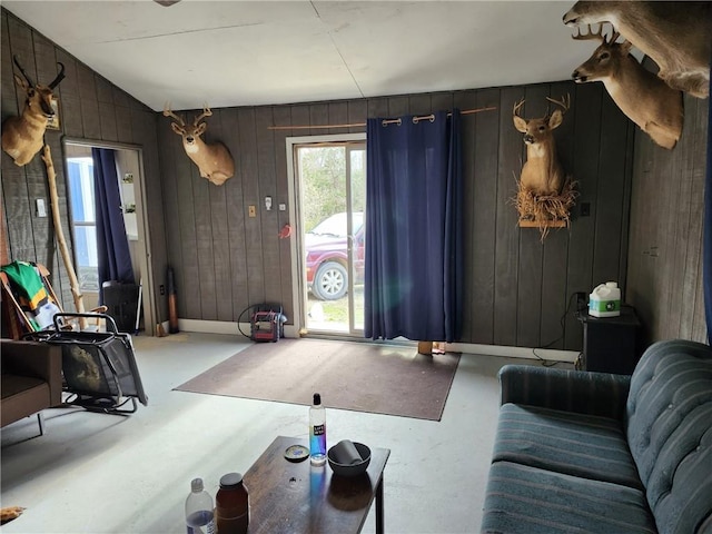 living room with wood walls and concrete floors