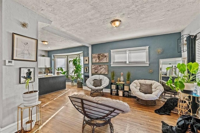 sitting room with a textured ceiling and light hardwood / wood-style flooring