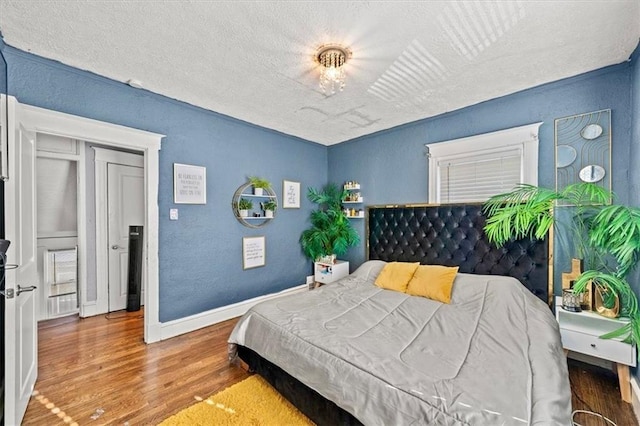 bedroom featuring hardwood / wood-style floors and a textured ceiling