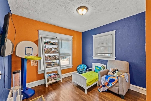 game room featuring a textured ceiling and dark hardwood / wood-style floors