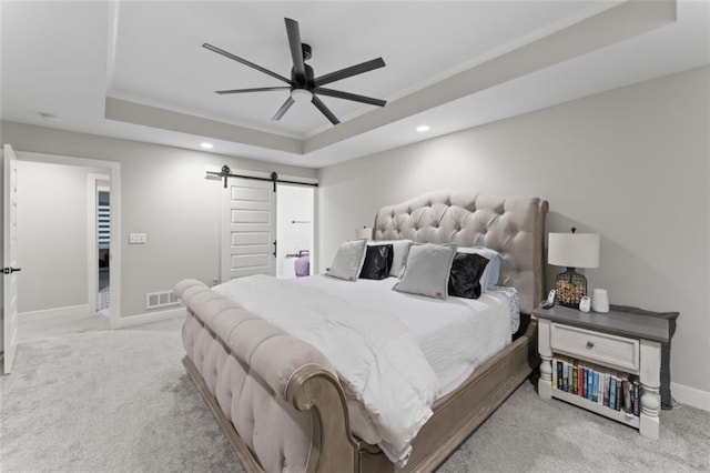 bedroom featuring light carpet, a raised ceiling, crown molding, ceiling fan, and a barn door