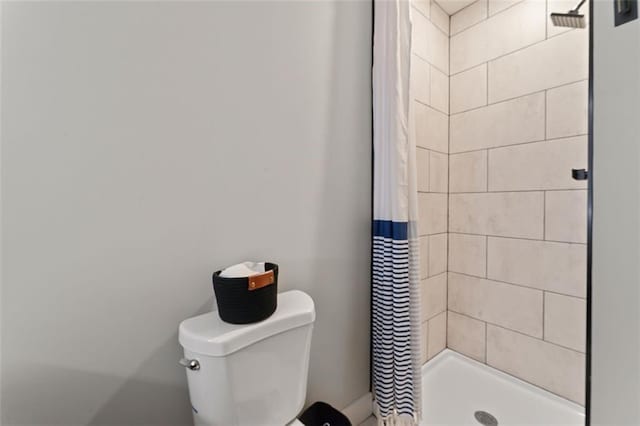 bathroom with a shower with shower curtain and toilet