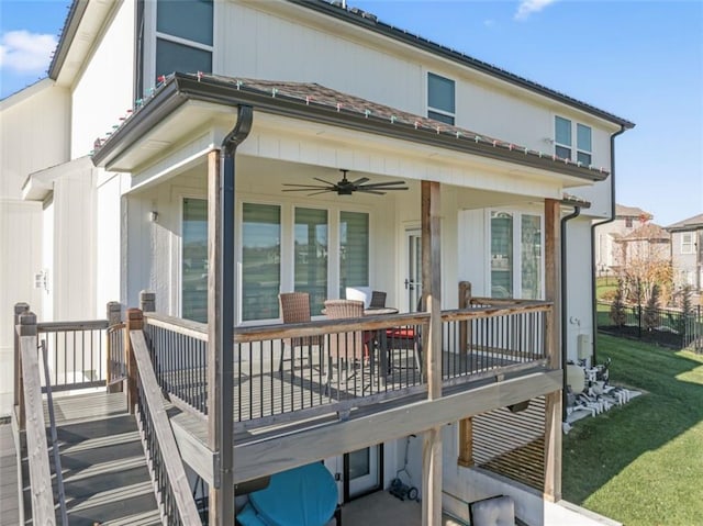 back of house with a lawn, ceiling fan, and a wooden deck