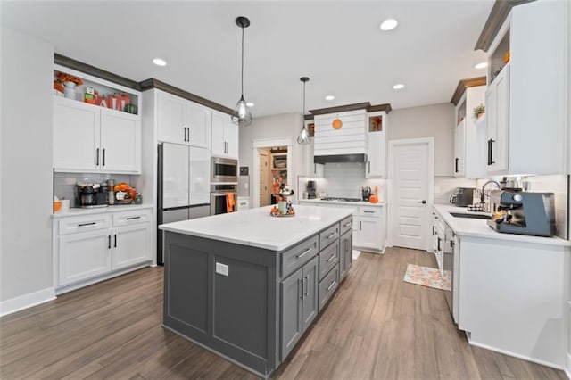 kitchen featuring pendant lighting, gray cabinets, a kitchen island, and white cabinetry