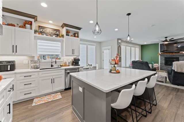 kitchen featuring white cabinetry, dishwasher, a center island, and sink