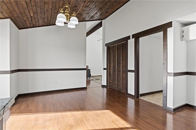 empty room featuring a chandelier, hardwood / wood-style floors, wooden ceiling, and lofted ceiling