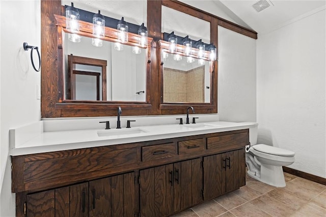 bathroom with tile patterned flooring, vanity, vaulted ceiling, and toilet