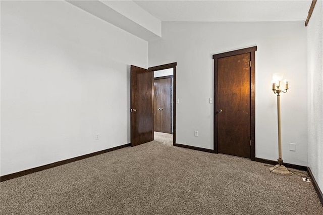 unfurnished bedroom featuring carpet floors and vaulted ceiling