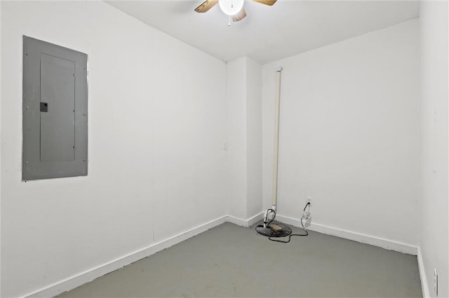 spare room with electric panel, ceiling fan, and concrete flooring