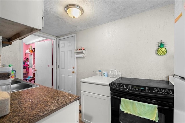 kitchen featuring sink, white cabinetry, a textured ceiling, and black electric range