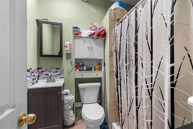 bathroom featuring vanity, toilet, decorative backsplash, and walk in shower