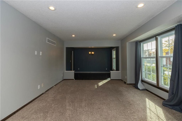 spare room with carpet and a textured ceiling