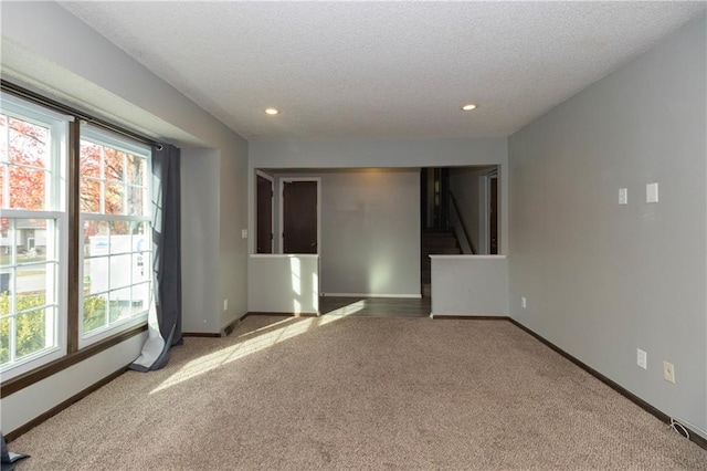 spare room featuring carpet and a textured ceiling