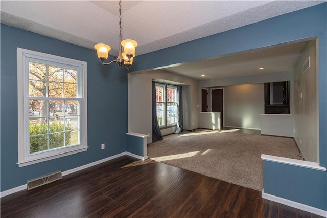 unfurnished room with dark hardwood / wood-style flooring and a chandelier