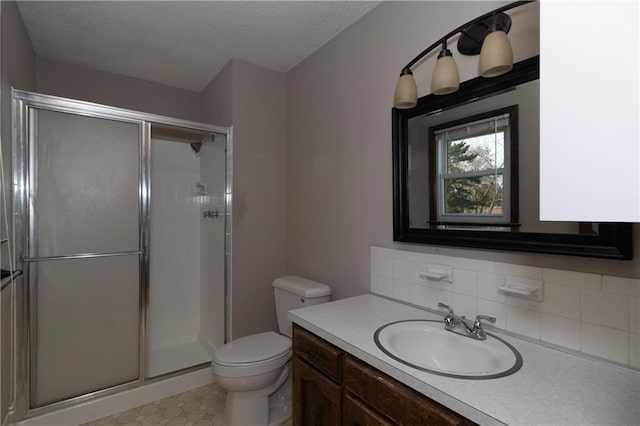 bathroom with a textured ceiling, vanity, toilet, and walk in shower