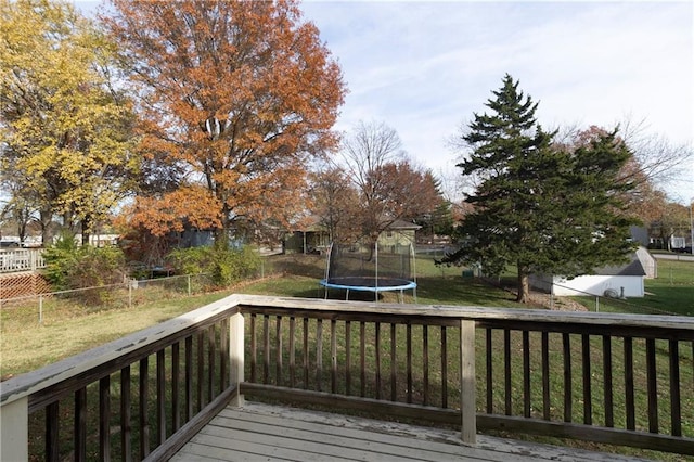 wooden terrace featuring a lawn and a trampoline