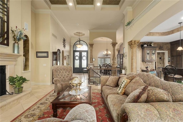 living room featuring a towering ceiling, ornamental molding, beamed ceiling, light tile patterned flooring, and decorative columns