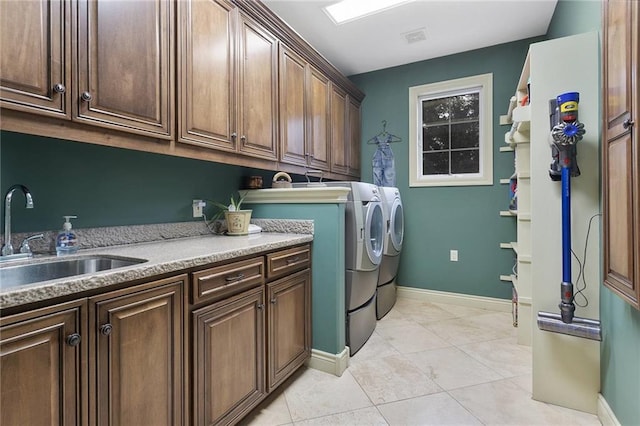 washroom with cabinets, light tile patterned flooring, washer and dryer, and sink