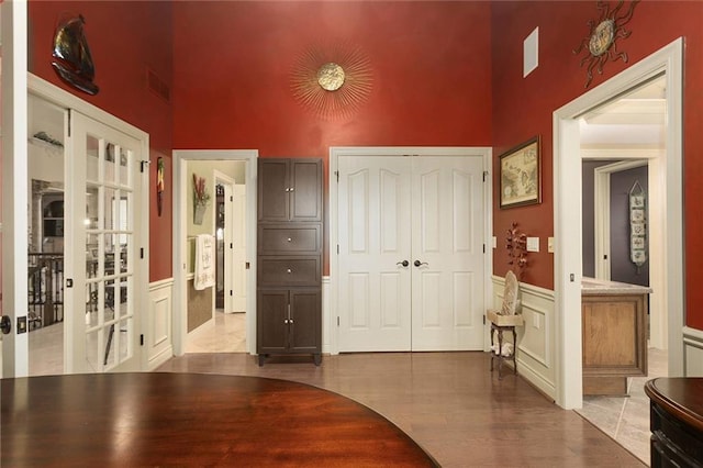 interior space with a high ceiling, light hardwood / wood-style flooring, and french doors