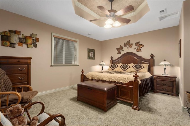 bedroom featuring light colored carpet, a raised ceiling, ceiling fan, and ornamental molding