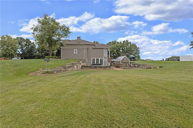 back of property featuring an outbuilding and a lawn