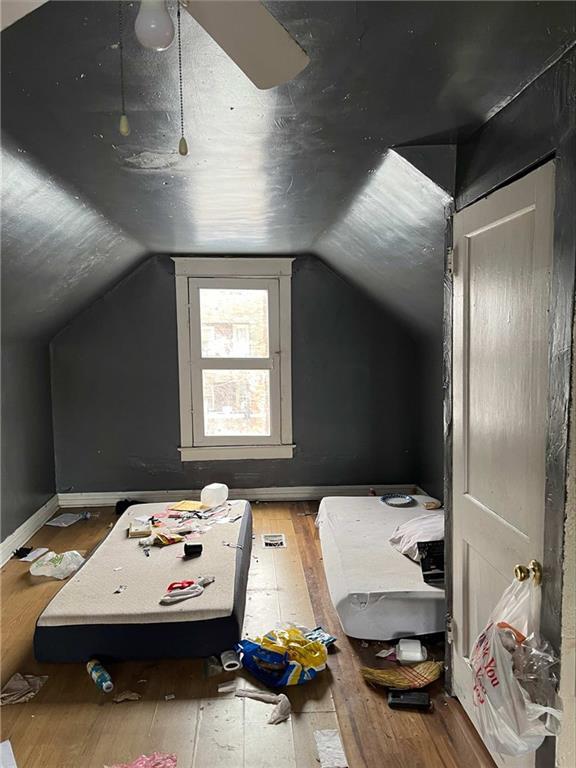 bonus room featuring wood-type flooring, vaulted ceiling, and baseboards