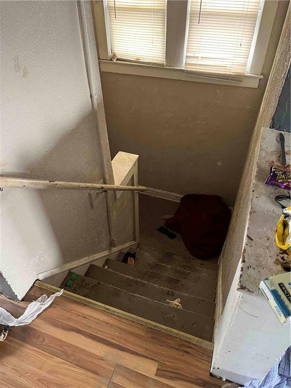 staircase with a healthy amount of sunlight and wood finished floors