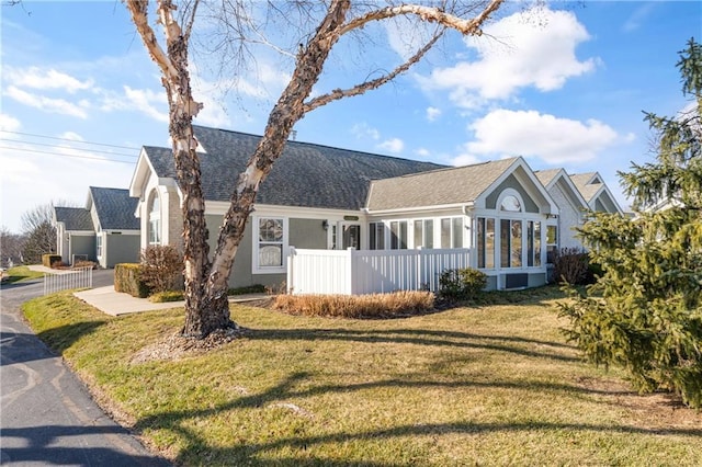 view of front of house featuring a sunroom and a front yard