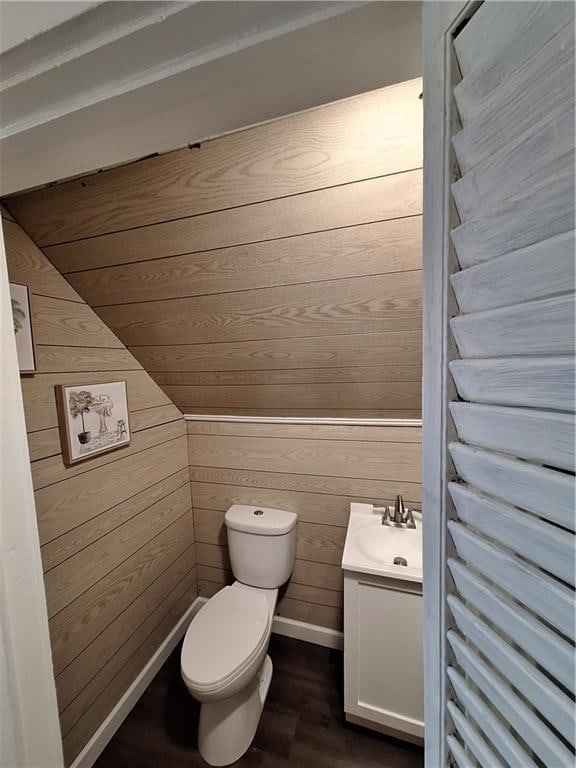 bathroom featuring wooden walls, vanity, and hardwood / wood-style flooring