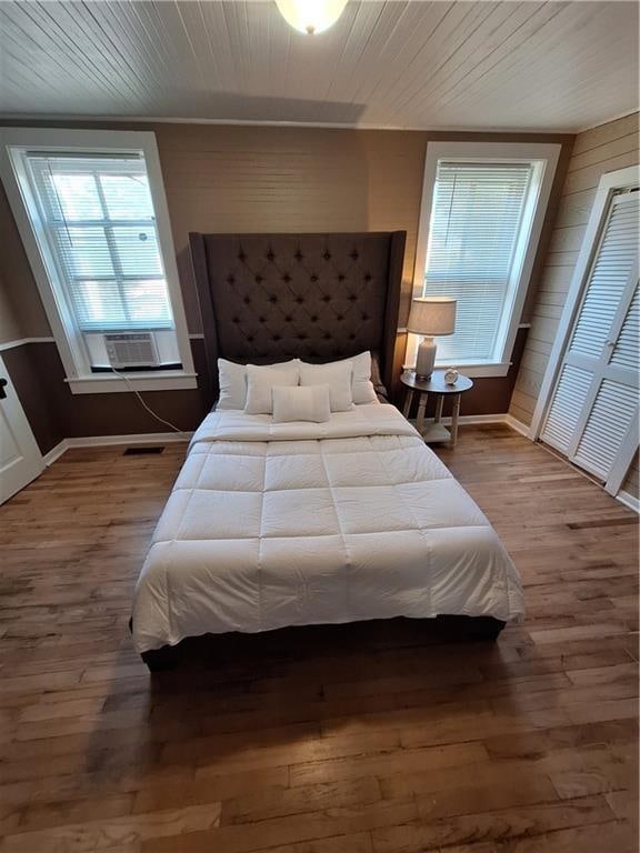 bedroom with hardwood / wood-style flooring, cooling unit, and wooden ceiling