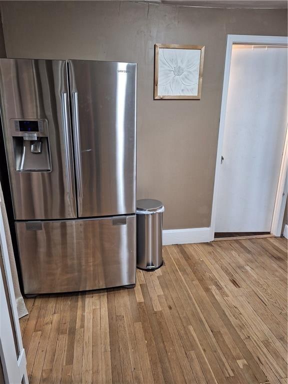 kitchen featuring stainless steel fridge and light hardwood / wood-style flooring