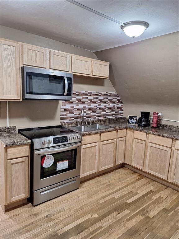 kitchen with sink, decorative backsplash, light wood-type flooring, light brown cabinetry, and appliances with stainless steel finishes