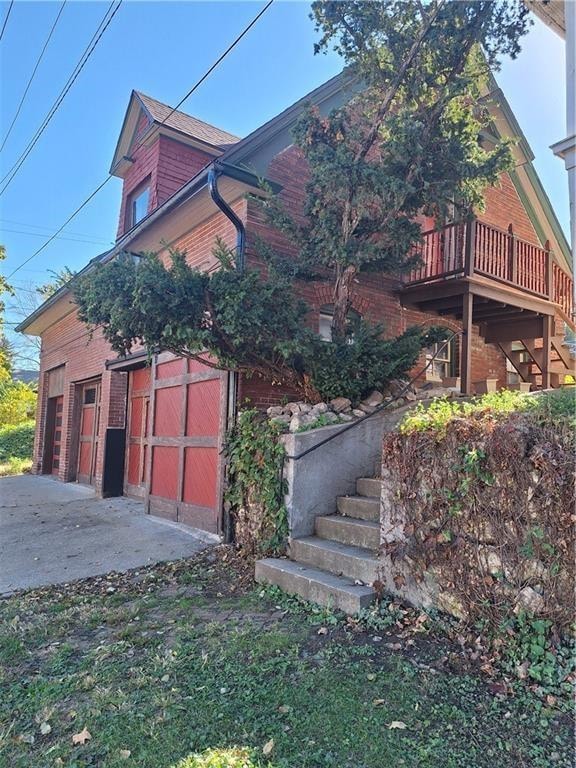 view of side of property featuring a garage and a balcony