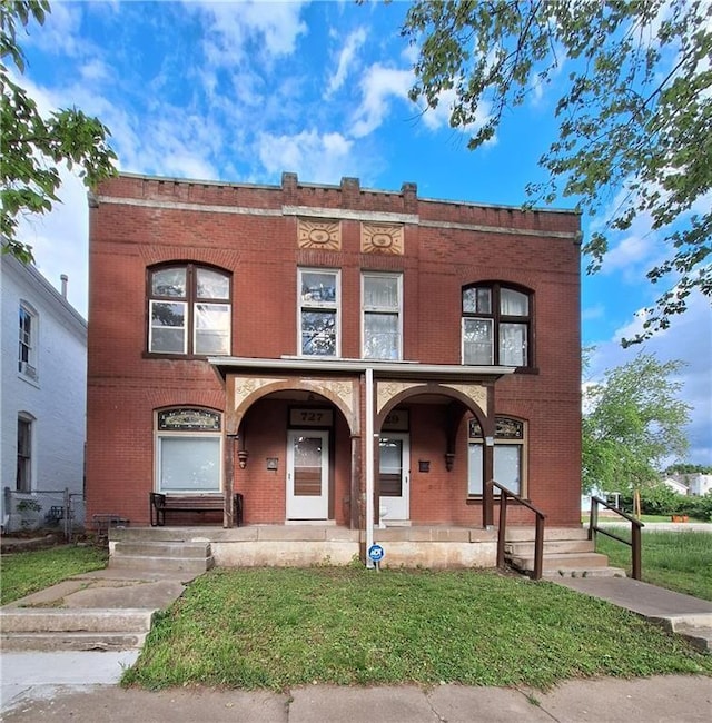 townhome / multi-family property featuring a porch and a front yard