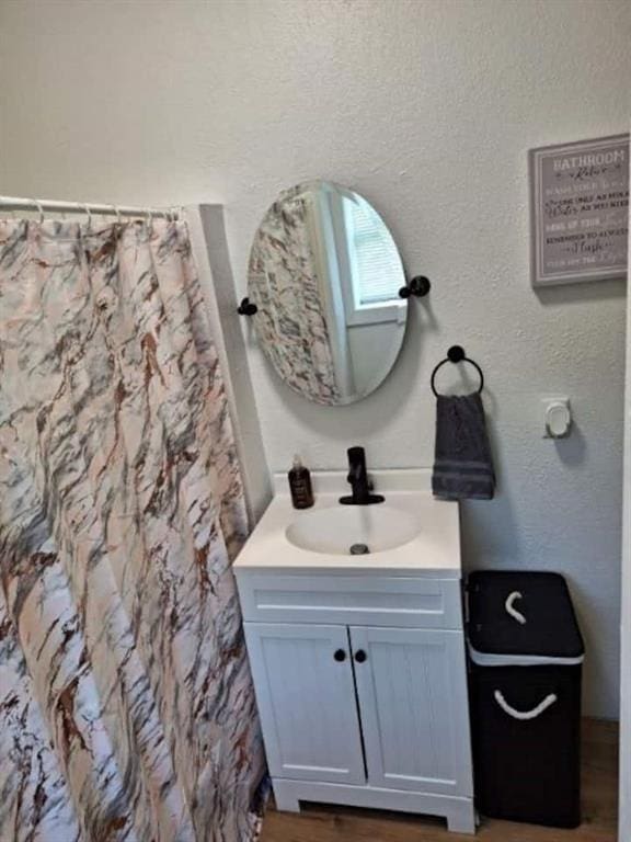 bathroom with a shower with shower curtain, vanity, and hardwood / wood-style floors