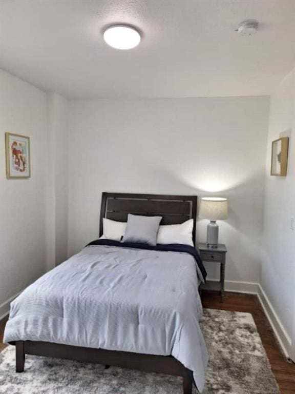 bedroom with dark hardwood / wood-style floors