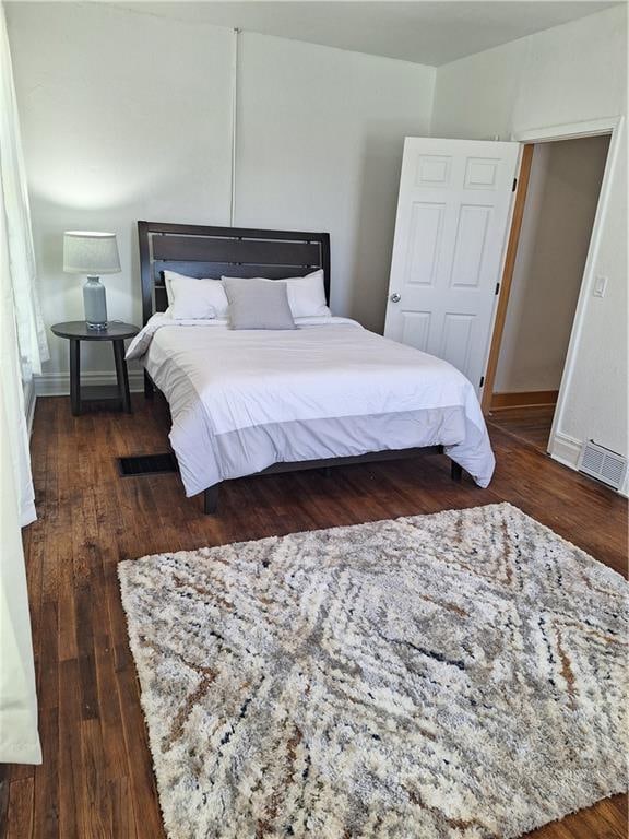 bedroom with dark wood-type flooring