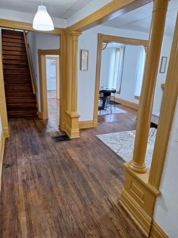 interior space with dark hardwood / wood-style floors and decorative columns