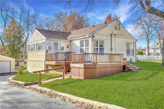 back of house featuring a wooden deck, a garage, and a lawn