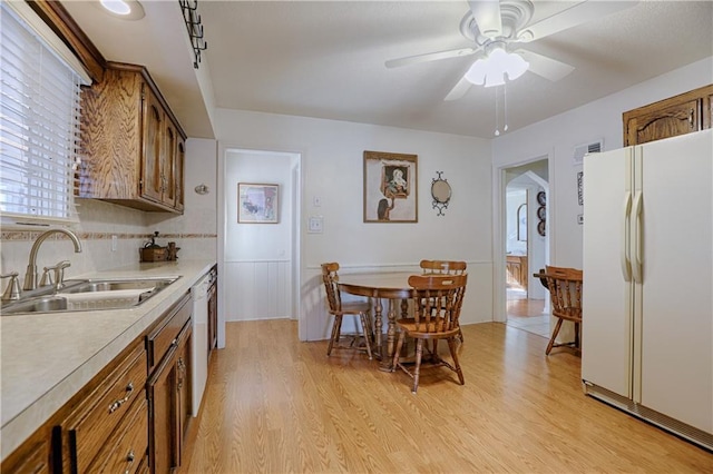 kitchen with ceiling fan, white appliances, sink, and light wood-type flooring